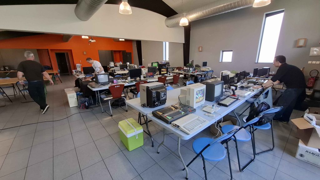 CrocoFest 2026 : Alignement d'ordinateurs vintage Amstrad et Enterprise 128 sur des tables de camping lors du festival rétro CrocoFest en bord de rivière.