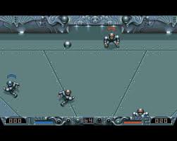 Speedball 2 : Brutal Deluxe (1990). l'arène métallique, les neuf joueurs par équipe, le multiplicateur de score — tout ce qui fit la légende du jeu est visible dès les premières secondes.